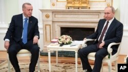 FILE - Turkey's President Recep Tayyip Erdogan, right, and Russia's President Vladimir Putin talk during a ceremony in Istanbul, Jan. 8, 2020.