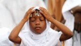 A girl prays during Eid el-Kebir at a mosque in Koumassi, in the Ivorian capital Abidjan. Muslims around the world celebrate Eid el-Kebir, also known as Eid al-Adha, by slaughtering sheep, goats, camels and cows to commemorate Prophet Abraham's willingness to sacrifice his son, Ismail, on God's command.