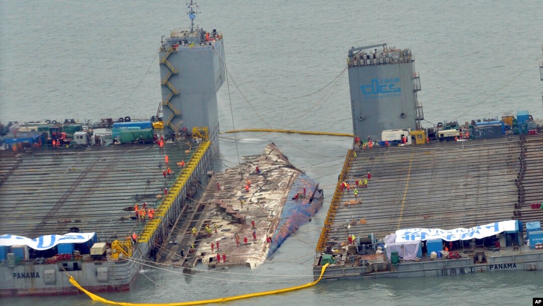 Para pekerja bersiap untuk mengangkat kapal feri Sewol tang tenggelam (tengah) di perairan Jindo, Korea Selatan, 23 Maret 2017. (Park Gyung-woo/Hankookilbo via AP)