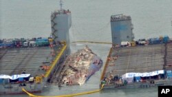 Para pekerja bersiap untuk mengangkat kapal feri Sewol tang tenggelam (tengah) di perairan Jindo, Korea Selatan, 23 Maret 2017. (Park Gyung-woo/Hankookilbo via AP)