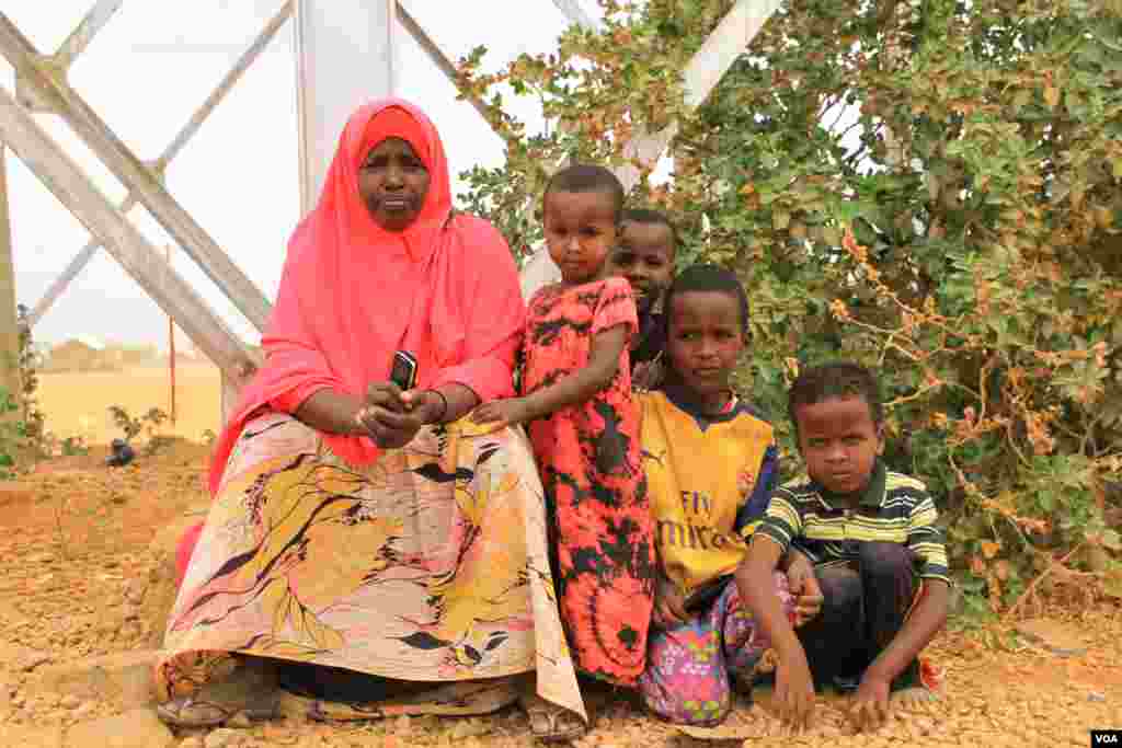 Seorang pengungsi dan anak-anaknya duduk dekat menara air di kamp pengungsi Dadaab di Kenya (19/9). (VOA/Jill Craig)