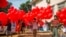 Anti-coup protesters hold red balloons carrying leaflets with various messages before releasing them during a gathering, in Yangon, Myanmar, March 24, 2021.