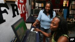 Ciata Victor instructs an unidentified lady inside her Internet cafe in Monrovia, (File photo).