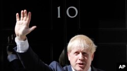 Britain's new Prime Minister Boris Johnson waves from the steps outside 10 Downing Street, London, Wednesday, July 24, 2019. 