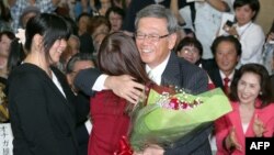 Former Naha Mayor Takeshi Onaga, right, hugs his daughter as they celebrate his victory in the Okinawa gubernatorial election in Naha, the capital of Japan's southern island of Okinawa, Nov. 16, 2014. 