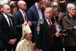 FILE - Rev. Mariann Edgar Budde, the Bishop of Washington is seen next to U.S. President Donald Trump and first lady Melania Trump, with Secret Service agents, attending a Christmas Eve church service at the National Cathedral.