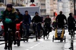 People ride bicycles alongside a traffic jam, in Paris, Dec. 20, 2019. France's punishing transportation troubles may ease up slightly over Christmas but unions plan renewed strikes and protests in January.
