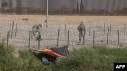 Пограничный патруль стоит на страже, когда мигранты пересекают Рио-Гранде в поисках убежища в США, как видно из Сьюдад-Хуареса, штат Чиуауа, Мексика, 3 октября 2023 года.