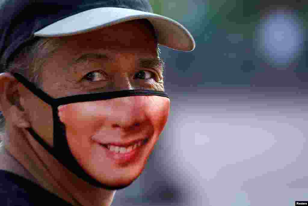 A man wearing a mask looks on as he sells matresses in Manila, Philippines.