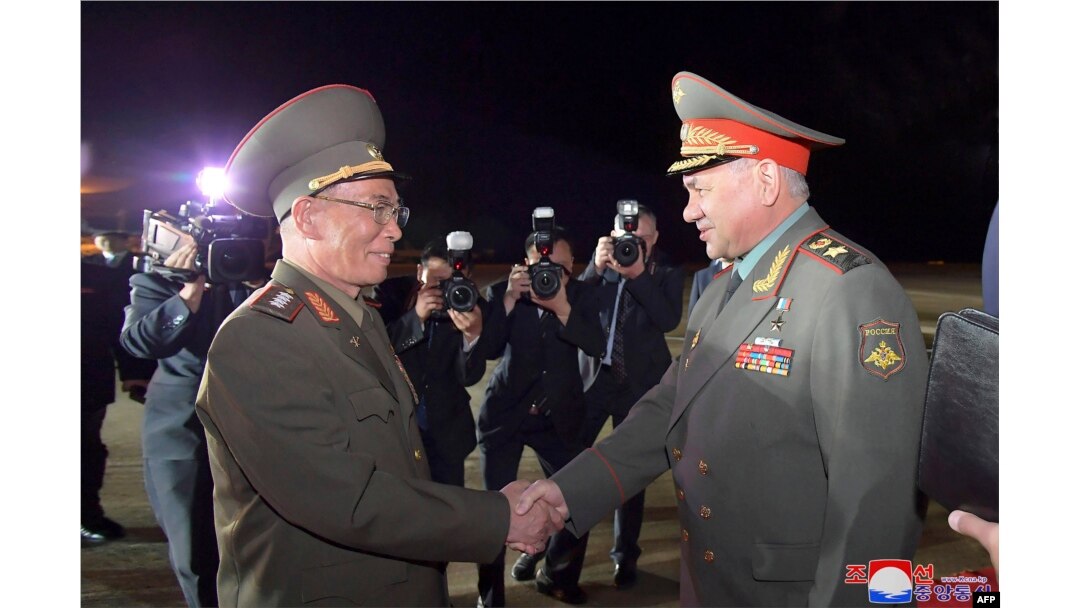 Kang Sun Nam, Menteri Pertahanan Nasional DPRK, menyapa Menteri Pertahanan Rusia Sergei Shoigu (kanan) setibanya di Bandara Internasional Pyongyang, 25 Juli 2023. (KCNA VIA KNS/AFP)