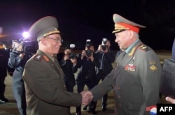 Kang Sun Nam, Menteri Pertahanan Nasional DPRK, menyapa Menteri Pertahanan Rusia Sergei Shoigu (kanan) setibanya di Bandara Internasional Pyongyang, 25 Juli 2023. (KCNA VIA KNS/AFP)