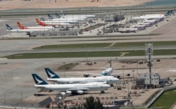 FILE - Cathay Pacific Airways and Dragon Airways planes are seen at the Hong Kong International Airport, Sept. 6, 2019.