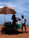 Muškarac kupuje hladno piće od prodavca pored puta po sunčanom danu u Mahawewi, selu sjeverno od Colomba, Šri Lanka, 29. februara 2024.