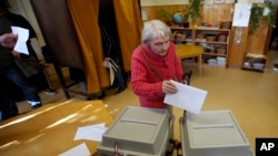 A voter casts her ballot at a polling station in Budapest, Hungary, Sunday, April 8, 2018. Orban is expected to win his third consecutive term, and fourth overall since 1998, as voting stations opened across the country for the election of 199 parliamentary deputies.