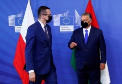 FILE - Poland's Prime Minister Mateusz Morawiecki and Hungary's Prime Minister Viktor Orban arrive ahead of a meeting with European Commission President Ursula von der Leyen in Brussels, Belgium, Sept. 24, 2020.