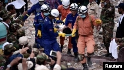 A rescue team carries out a wounded worker from a collapsed building in Sihanoukville, Cambodia June 24, 2019. 