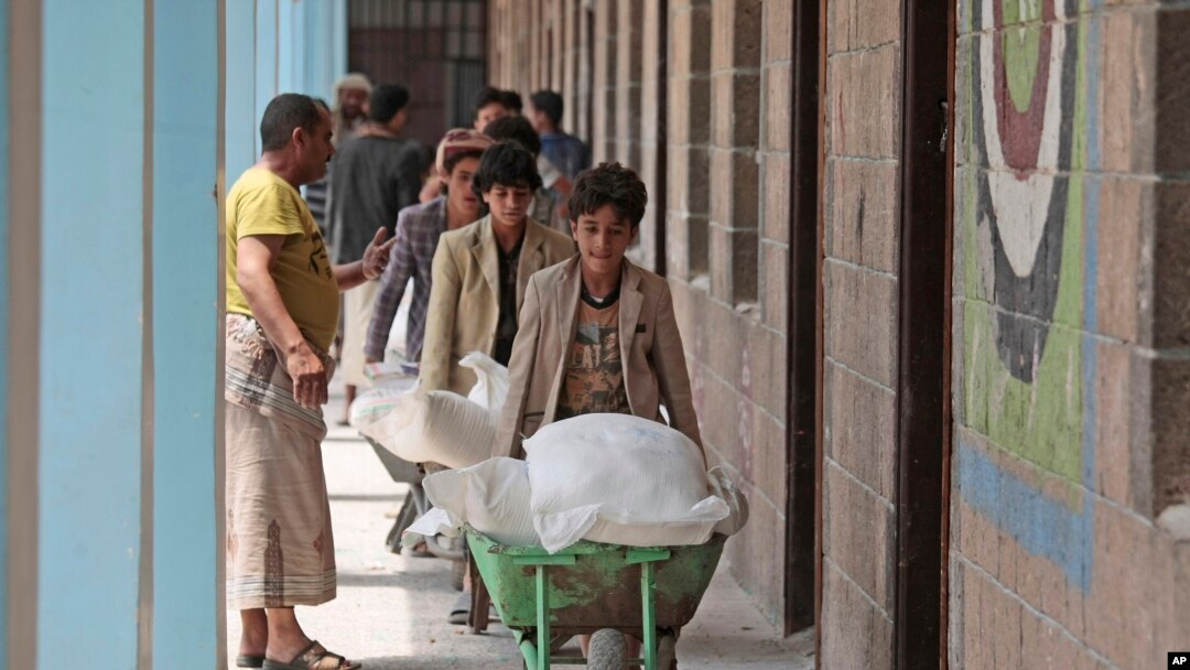 Displaced Yemenis receive food supplies provided by the World Food Programme, at a school in Sanaa, Yemen, Sunday, Aug. 25, 2019. 