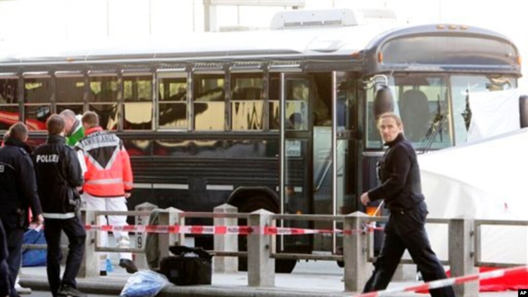 Police officers investigate the crime scene after a gunman fired shots at US soldiers on the bus outside Frankfurt airport, Germany, killing two airmen and wounding two before being taken into custody, March 2, 2011