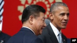 FILE - China's President Xi Jinping, left, and then-U.S. president Barack Obama are seen at a summit in Lima, Peru, Nov. 20, 2016. Xi reportely hosted Obama Thursday in Beijing.