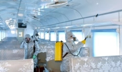This undated picture released from North Korea's official Korean Central News Agency (KCNA) on Feb. 15, 2020, shows people in protective suits spraying disinfectant at an undisclosed location in North Korea amid concerns about the coronavirus.