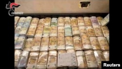 Seized money is displayed in an unknown location following an operation of the Carabinieri del Ros and the Provincial Command of Reggio Calabria in Italy and in various foreign countries in this still photo released today May 3, 2023. 