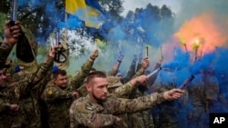 Ukrajinski vojnici brigade Azov pale baklje tokom ceremonije sahrane poginulog saborca u Travkinu, Černigovska oblast, Ukrajina, 4. oktobra 2024.