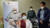 El presidente de Bolivia, Luis Arce, observa el momento en que una empleada de la salud recibe la vacuna rusa Sputnik V contra la enfermedad por coronavirus (COVID-19) en el Hospital del Norte en El Alto, afueras de La Paz, Bolivia, 30 de enero de 2021.