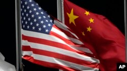 Bendera Amerika dan China berkibar dmenjelang Olimpiade Musim Dingin 2022 di Zhangjiakou, China. Beijing pada Jumat (3/2) mengatakan sedang berupaya memverifikasi laporan AS bahwa sebuah balon mata-mata China sedang terbang di atas AS. (Foto: AP)