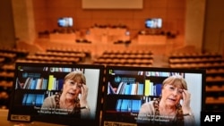 A picture taken on February 25, 2021 shows United Nations High Commissioner for Human Rights Michelle Bachelet on a screen as she speaks on Belarus via video-link during a session of the UN Human Rights Council in Geneva. - The United Nations rights…