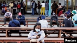 Orang-orang yang memakai masker terlihat duduk pada jam-jam sibuk di stasiun kereta api di tengah wabah COVID-19 di Jakarta, 13 September 2021. (Foto: REUTERS/Ajeng Dinar Ulfiana)