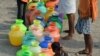 Indian residents queue with plastic containers to get drinking water from a tanker in the outskirts of Chennai, May 29, 2019. An unrelenting heat wave triggered warnings of water shortages and heatstroke in India on June 1.