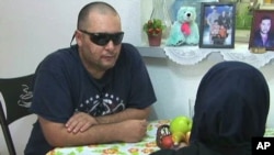 Iraqi immigrants Hayder Abdul-Wahab (left) and his wife Iman study English at their home in Tampa, Florida