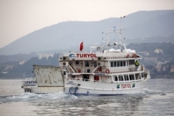 FILE - A Turkish-flagged passenger boat carrying migrants to be returned to Turkey leaves the port of Mytilene on the Greek island of Lesbos, April 8, 2016.