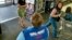FILE - A store greeter offers help to shoppers at a Walmart store in West Norriton, Pa.
