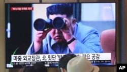 FILE - In this Aug. 2, 2019, file photo, people watch a TV showing a file footage of North Korean leader Kim Jong Un during a news program at the Seoul Railway Station in Seoul, South Korea.