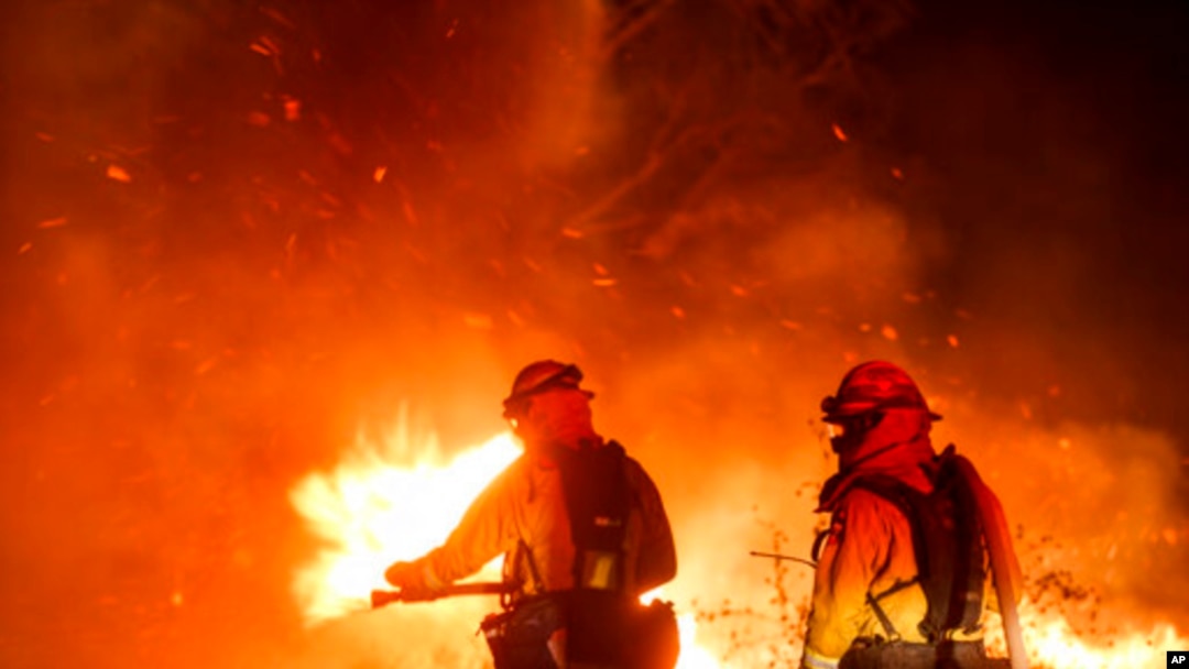 Para petugas pemadam kebakaran memadamkan api kebakaran lahan di Riverside, California, 31 Oktober 2019. (Foto: AP)