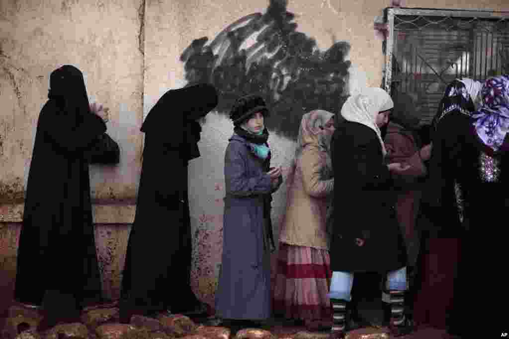 Women queue for hours on December 12 to buy bread at a bakery in Maaret Misreen in Syria's Iblib province. (AP)