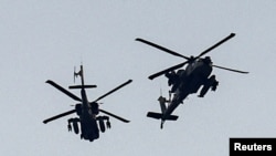 FILE - Israeli military helicopters fly near the Israel-Gaza border, amid the ongoing conflict between Israel and the Palestinian Islamist group Hamas, as seen from southern Israel, December 7, 2023