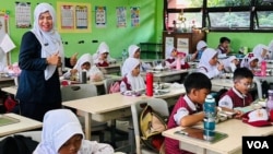 Children devour   a escaped  repast  astatine  school. (Devianti Faridz/VOA)