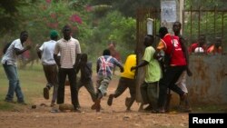 A crowd runs for cover as African Union (AU) peacekeeping soldiers fire warning shots to disperse a crowd near the district of Miskine in Bangui, Feb. 7, 2014. 