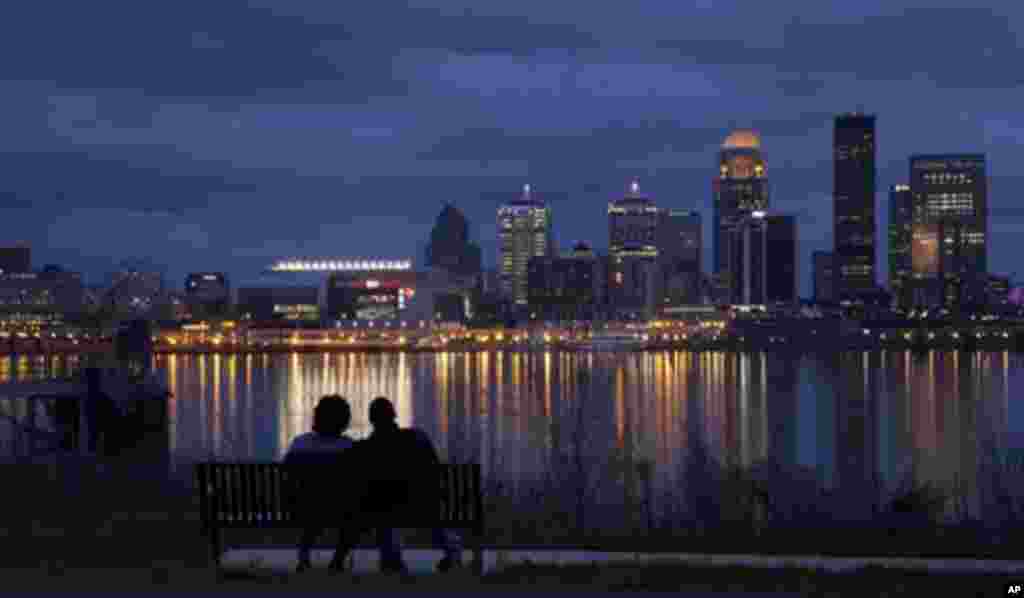 George Murff of Indianapolis sits with his friend Jasmine Riddlespriger of Clarksville, Ind., as they watch the Ohio river flow past Louisville, Ky., Friday, March 16, 2012. (AP Photo/Dave Martin)