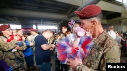 FILE - Sean Smith, a paratrooper with the 1st Brigade Combat Team, 82nd Airborne Division, kisses his daughter Olivia Rose Smith, 10 months, after returning home from Afghanistan at Pope Army Airfield in Fort Bragg, North Carolina, Nov. 5, 2014.