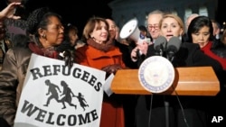 Ketua minoritas DPR AS Nancy Pelosi (kedua dari kiri) bersama para anggota Kongres lainnya, menyaksikan Farah Amer Kamal, dari Irak, berbicara dalam protes atas inpres Presiden Donald Trump di depan Mahkamah Agung di Washington (30/1). (AP/Alex Brandon)