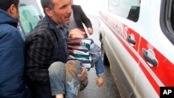 A man carries a wounded boy to an ambulance after an earthquake hit villages in Baskale town in Van province, Turkey, at the border with Iran, Feb. 23, 2020. 