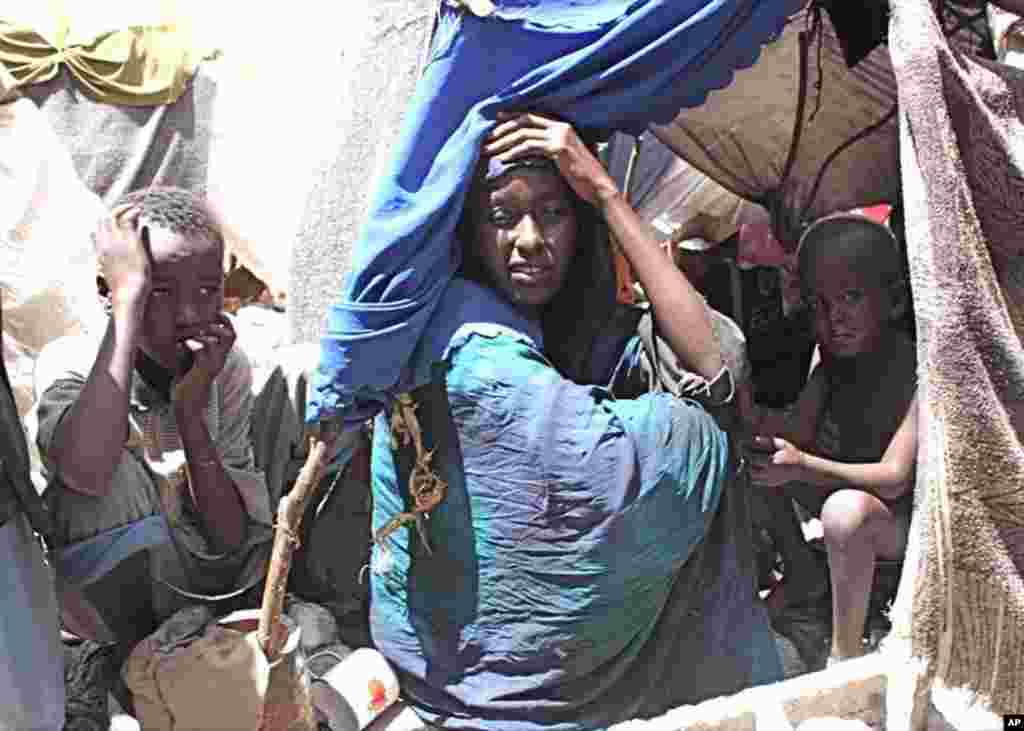 Hamsa Ali, with two of her five remaining children, tells how her 3-year old son died a day earlier of measles complicated by malnutrition. (VOA - P. Heinlein)