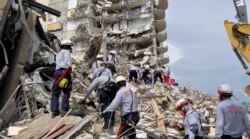 In this image, released by the Miami-Dade Fire Department, rescuers search for survivors in the rubble of the Champlain Towers South building in Surfside, Florida, on June 25, 2021.