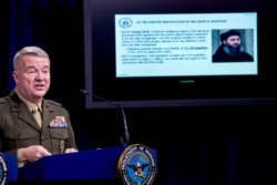 FILE - Positive identification information on Abu Bakr al-Baghdadi is displayed as U.S. Central Command Commander Marine Gen. Kenneth McKenzie speaks, Oct. 30, 2019, at a joint press briefing at the Pentagon in Washington.