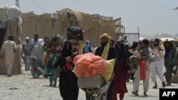 Orang-orang berjalan melewati pos perlintasan di kota perbatasan Chaman, di wilayah Pakistan, 17 Juli 2021, setelah negara itu membuka sebagian perbatasan selatan dengan Afghanistan yang sempat ditutup ketika Taliban menguasai. (Foto: AFP)