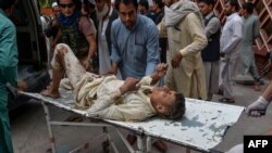 Volunteers carry an injured man on a stretcher to a hospital, following a bomb blast in Haska Mena district of Nangarhar province, Oct. 18, 2019.