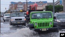 Cars drive through a flooded road at the entrance to Long Beach Island in Ship Bottom, N.J. on Oct. 11, 2019. 